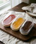 Three sealed panna cotta containers, chilled as they arrive
