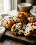 Raisin bread roll torn open showing plump raisins through the crumb