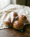 Four chocolate chip bread rolls sealed in a clear bag, as they arrive