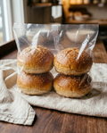 Four sesame burger buns sealed in a clear bag, as they arrive