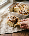 Cinnamon roll partly unrolled showing the cinnamon filling inside