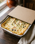 Vegetarian lasagna in its sealed aluminium tray, chilled as it arrives